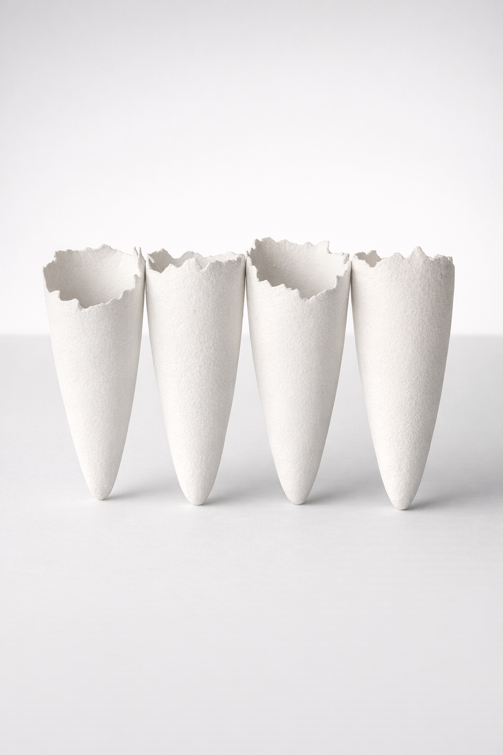 4 White Ceramic Joined Vases At Angle