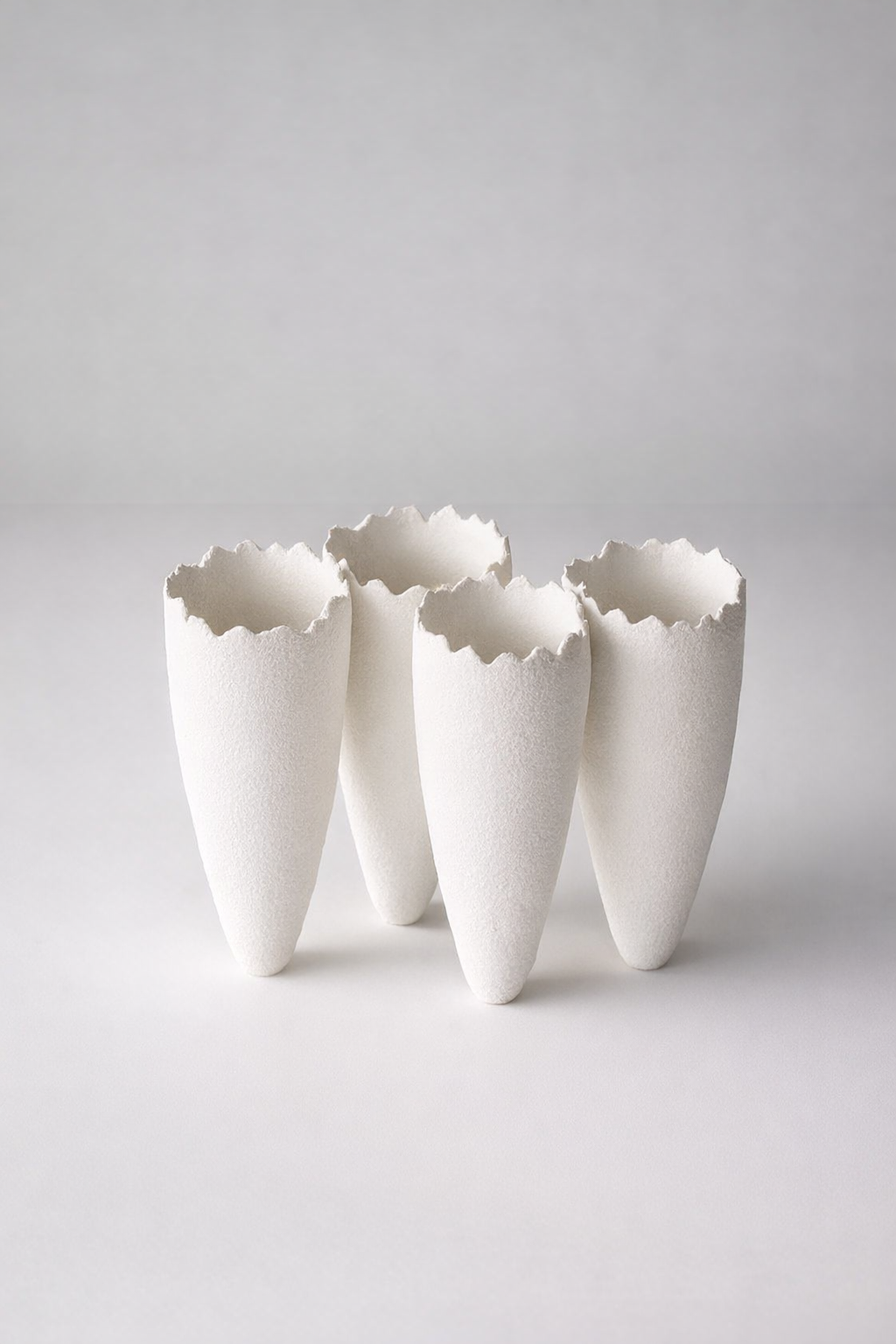 4 White Ceramic Vases Joined Upright